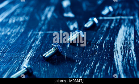 Nuts for repairs lying on a wooden table. Stock Photo