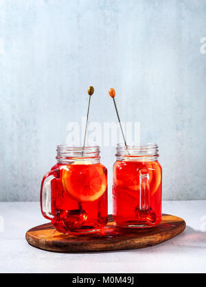 chilled karkade tea with lemon on a wooden stand on a stone table and background. antioxidants, spasmolytic, diuretic, antipyretic properties. Stock Photo