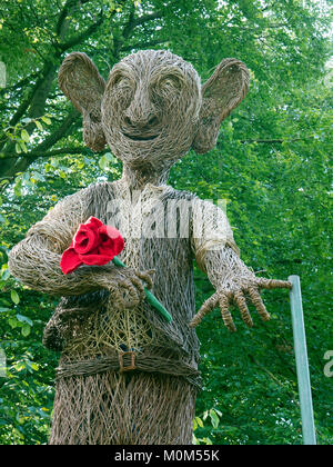 Willow sculpture of BFG (big friendly giant) ,holding a knitted red rose, at RHS garden Harlow Carr, Yorkshire Stock Photo