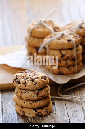 Close-up of several piles of chocolate cookies on wooden table. Stock Photo