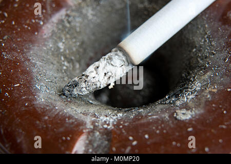 Ashtray full of ash with cigarette in it Stock Photo