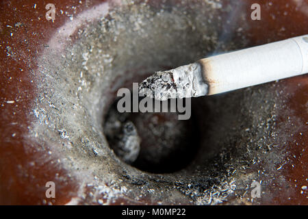 Ashtray full of ash with cigarette in it Stock Photo