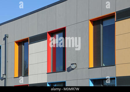 Cladding detail of a new London primary school showing brightly coloured window reveals and grey wall panels. Stock Photo