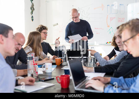 Relaxed informal IT business startup company meeting. Team leaders discussing and brainstorming new approaches and ideas with colleagues. Startup busi Stock Photo