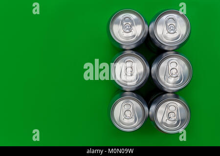 Silver metal drinks cans overhead on green background Stock Photo