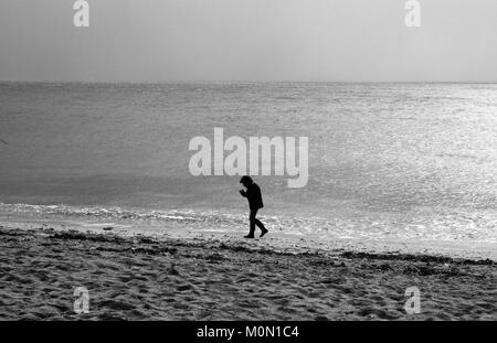 A tourist walks along Towan Beach, near Portscatho on the Roseland Peninsula, in Cornwall, Britain December 29, 2017 Stock Photo