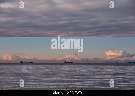 Seascape with ship at sunset with sky overcast and mountains in background. Stock Photo