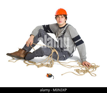 A young worker in grey uniform tied up with rope on white isolated background. Stock Photo
