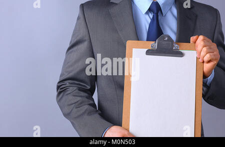 Young man standing with folder, isolated on gray background Stock Photo