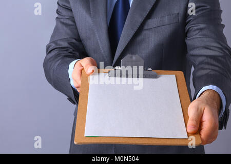 Young man standing with folder, isolated on gray background Stock Photo
