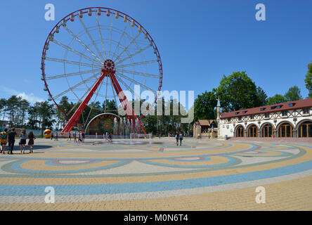 Kharkov, Ukraine - June 10, 2014: People resting in front of the Ferris wheel in the Central park named after M. Gorky. The Ferris wheel is 55 m tall, Stock Photo