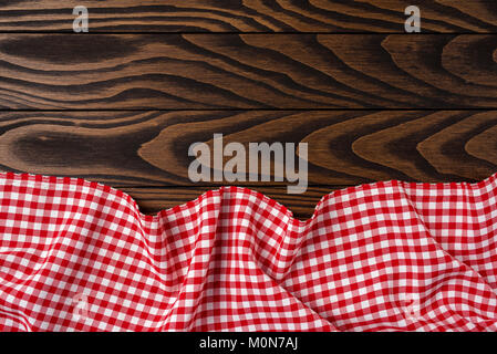 Red checkered tablecloth on an old wooden table. Close up Stock Photo