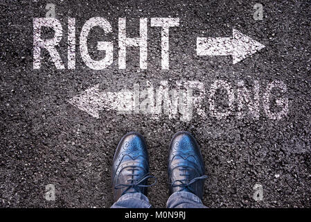 Feet and words right and wrong painted on an asphalt road Stock Photo