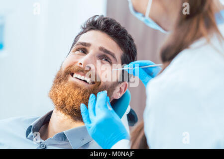 Reliable dentist using sterile instruments while cleaning the te Stock Photo