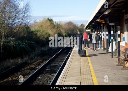 People waiting at a railway platform in a small town in England. Stock Photo