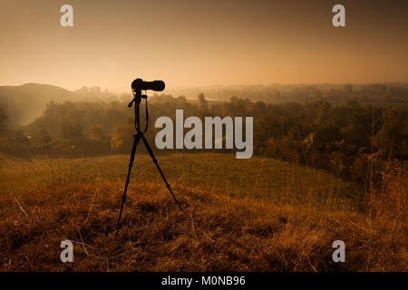 Digital camera with telephoto lens on tripod in nature. Stock Photo
