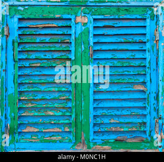 Layers of peeling paint on wooden window shutters Stock Photo