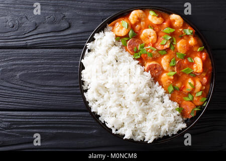 Delicious gumbo with prawns, sausage and rice on a plate on the table. horizontal top view from above Stock Photo