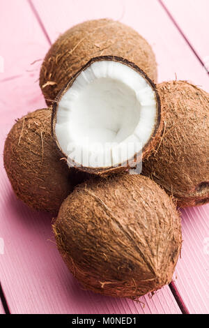 The halved coconuts on pink table. Stock Photo