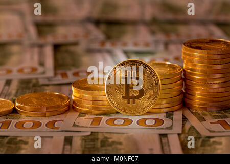 Bitcoins stacked on new design 100 dollar bills Stock Photo