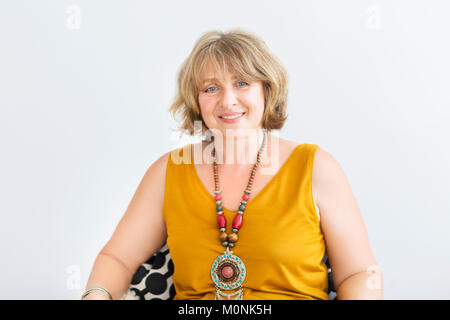 Mature woman sitting on chair in the living room Stock Photo