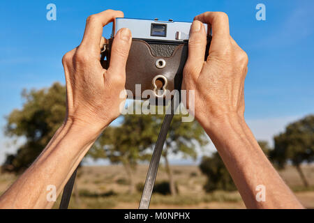 Woman hands holding a film vintage camera taking pictures Stock Photo