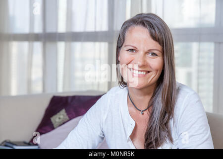 Happy smiling mature woman in her urban apartment Stock Photo