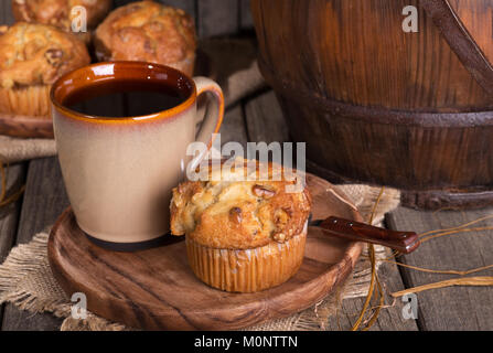 Banana nut muffin and cup of coffee on a wooden plate in a rustic setting Stock Photo