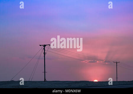Sunset nearly finished with only half of the sun showing, making the light even more red. Stock Photo