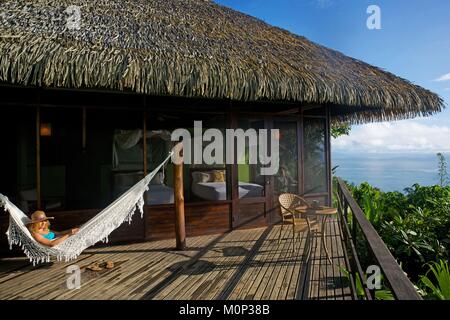 Costa Rica,Osa peninsula,woman in her hammock in the terrasse of the ecolodge Lapa Rios surounding the primary forest Stock Photo