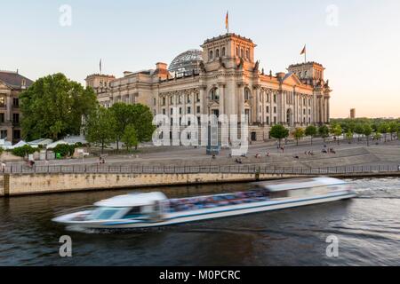Germany,Berlin,the Reichstag and the glass dome of the architect Sir Norman Foster,which became the Bundestag (German parliament since 1999),and a tourist boat on the River Spree Stock Photo