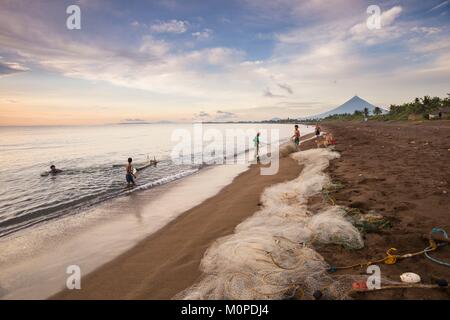 Philippines,Luzon,Albay Province,Tiwi,fishermen bringing a fishnet on the beach with Mayon volcano in back ground Stock Photo