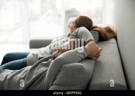 Relaxed couple resting or having nap leaning on comfortable sofa Stock Photo