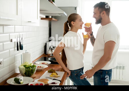 Young smiling loving couple preparing breakfast in the kitchen t Stock Photo