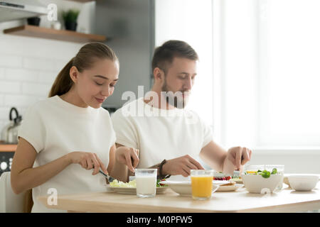 Young couple having dinner, tasting breakfast, eating together a Stock Photo