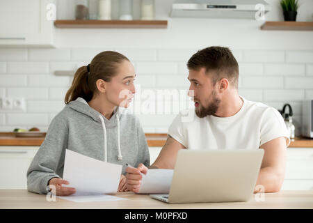 Young couple arguing about bills or document at home kitchen Stock Photo