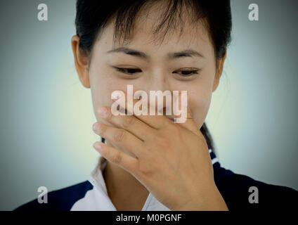 Shy North Korean woman with her hand on her mouth, Pyongan Province, Pyongyang, North Korea Stock Photo