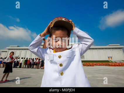 North Korean boy in army uniform putting his kepi in Grand monument of Mansu hill, Pyongan Province, Pyongyang, North Korea Stock Photo