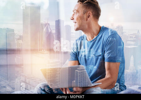 Positive delighted young man working at home Stock Photo