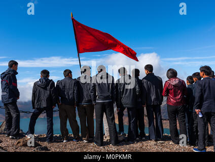 Group of students with red flag in front of lake at mount Paektu, Ryanggang Province, Mount Paektu, North Korea Stock Photo