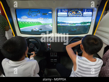 North Korean child on a car simulator in Kaeson youth park, Pyongan Province, Pyongyang, North Korea Stock Photo