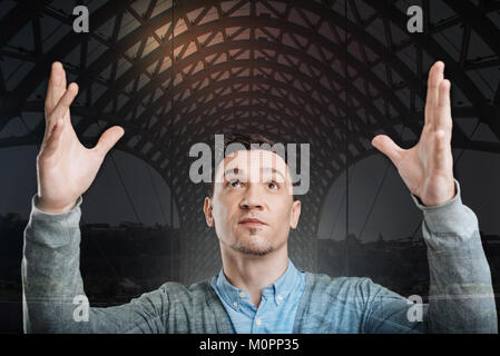 Motivated millennial gentleman holding his hands up Stock Photo