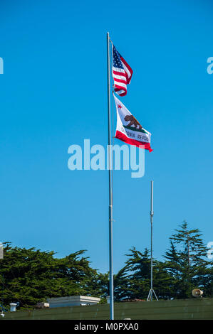 The flags of USA and California waving in the wind against a bright blue sky Stock Photo