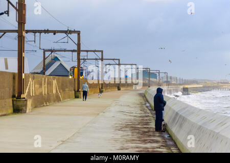 Saltcoats, Scotland, UK. 24th January  2018. UK Weather: A train passing through Saltcoats travels next to the coastline as high winds cause waves to crash against the sea wall. Storm Georgina is the seventh named storm of the season and is forecast to bring high wind and rain sweeping easterly across Britain.Credit: Skully/Alamy Live News Stock Photo