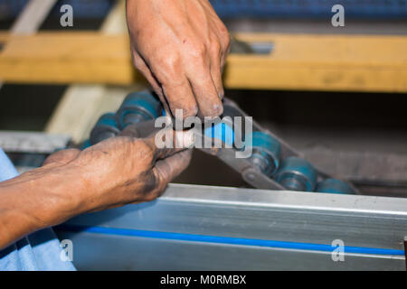 The technician repairing conveyor belt in factory Stock Photo