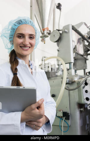 Portrait of quality control inspector smiling during inspection  Stock Photo