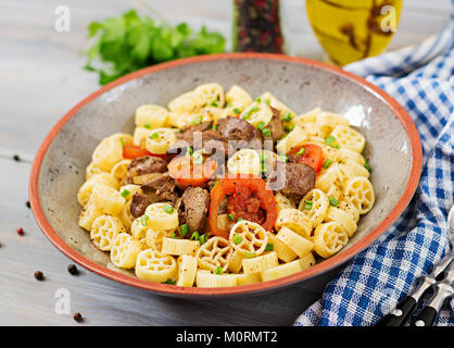 Fried chicken liver with tomato and garnish of pasta Stock Photo