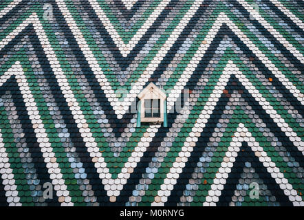 Small window on on the wall painted with blue, green and white stripes in zigzag. St. Stephen's Cathedral, Vienna, Austria. Minimalism concept Stock Photo