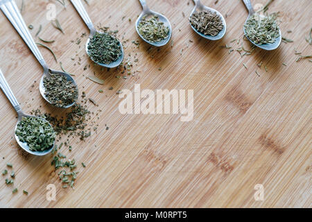Various dry seasonings and herbs on a wooden background Stock Photo