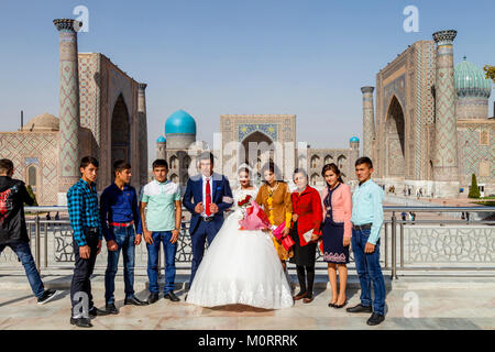 A Wedding Party Poses For Photos At The Registan Complex, Samarkand, Uzbekistan Stock Photo